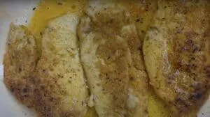 Golden-seared fish fillets seasoned with herbs and spices, served in a savory garlic butter sauce.